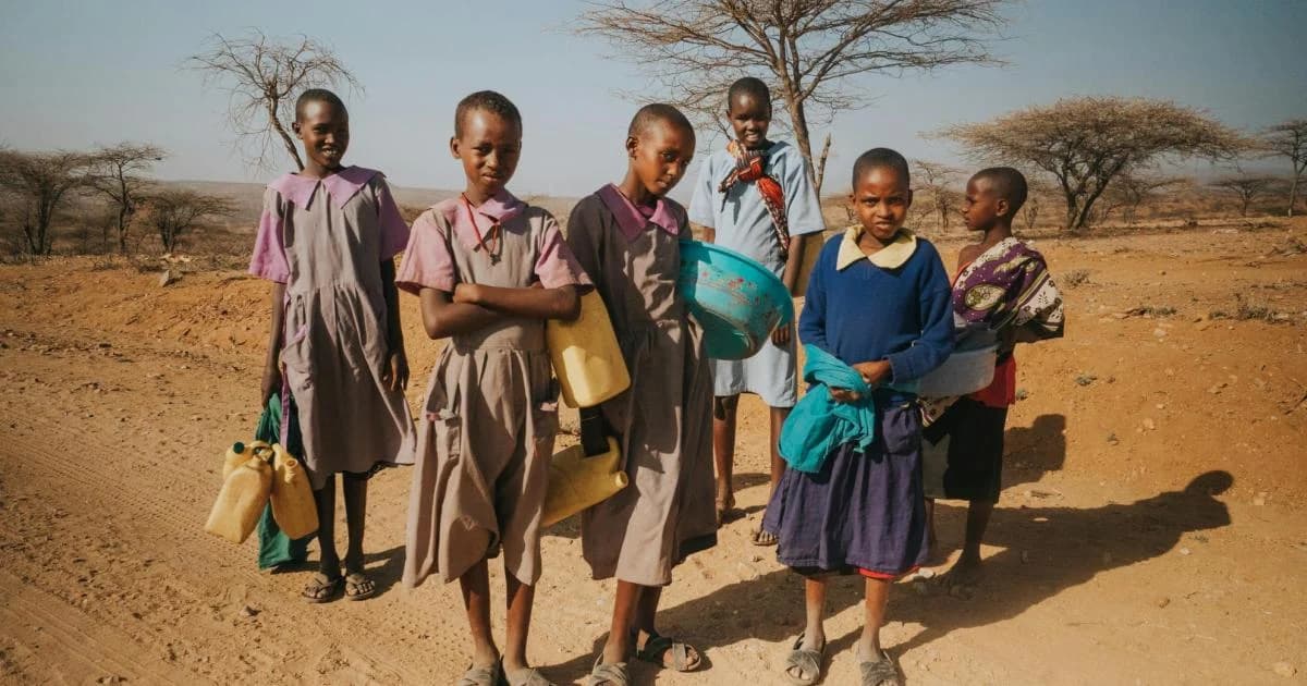 Des écolières transportant des récipients d’eau dans une zone rurale africaine