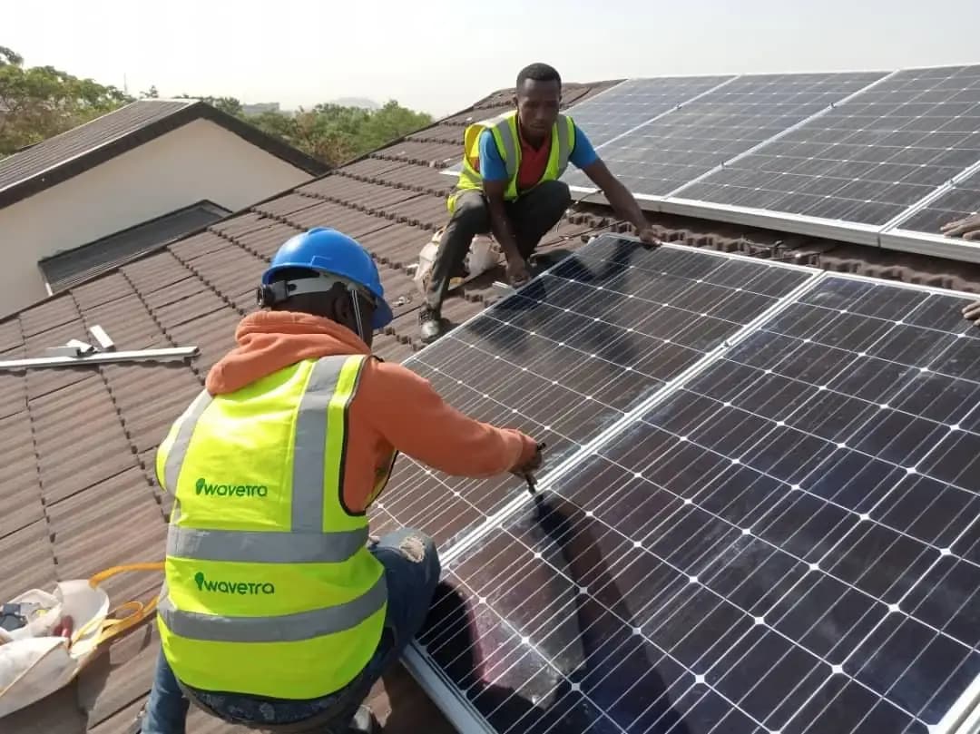 Deux techniciens installent des panneaux photovoltaïques au Nigeria, photo d’archive d’avril 2020